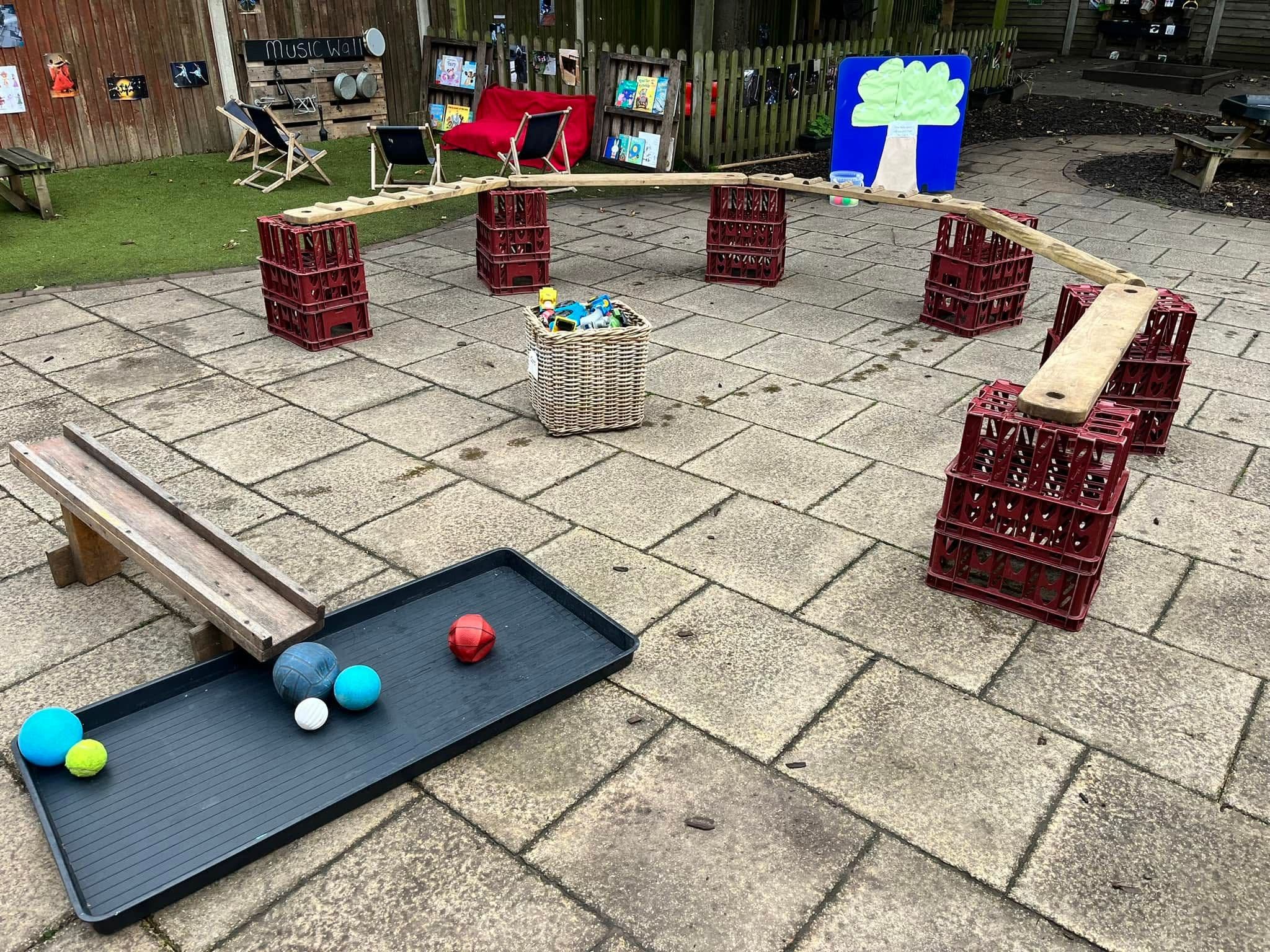 An outdoor balance and obstacle course built from crates and wooden planks.